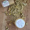 Lip-Scrub-Open Plastic free Rose Kisses Lip balm, dried chamomile and Honey Chamomile Lip balm on rustic wooden board