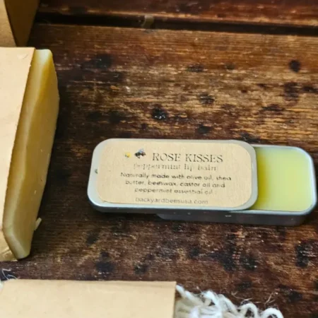 Snow Day Rose Kisses Close Open Rose Kisses peppermint beeswax lip balm in a vintage slider tin