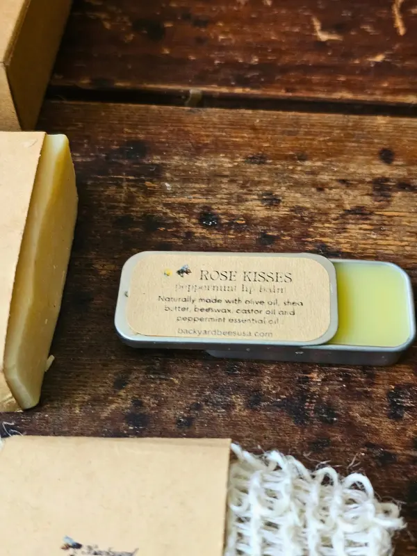 Snow Day Rose Kisses Close Open Rose Kisses peppermint beeswax lip balm in a vintage slider tin