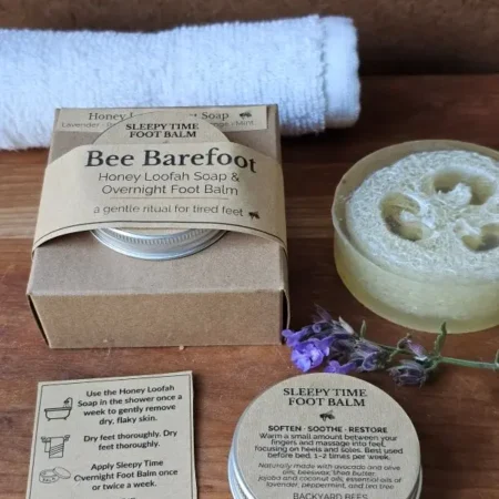 Bee Barefoot Duo with boxed set, Honey Loofah Foot Soap, Sleepy Time Foot Balm, white towel, and ritual card arranged in a clean flat lay.