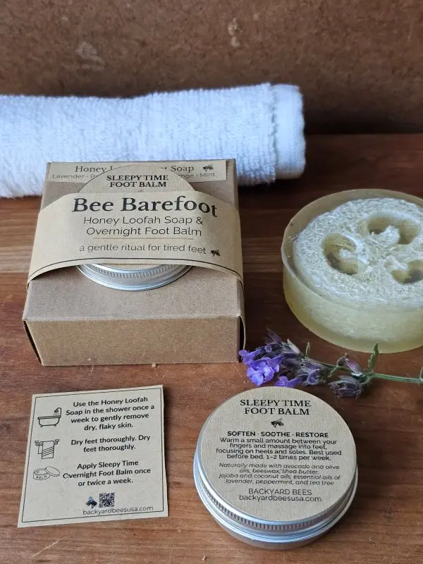 Bee Barefoot Duo with boxed set, Honey Loofah Foot Soap, Sleepy Time Foot Balm, white towel, and ritual card arranged in a clean flat lay.