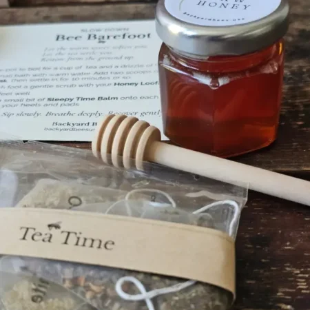 Small raw honey jar, wooden dipper, and tea sachets wrapped with a Tea Time band