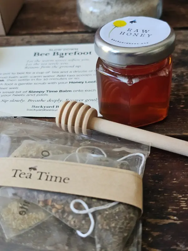 Small raw honey jar, wooden dipper, and tea sachets wrapped with a Tea Time band