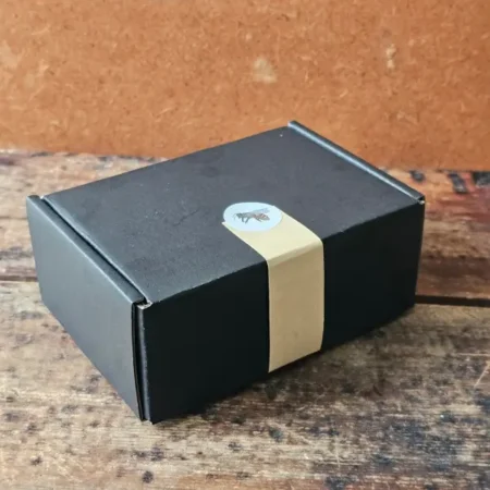 Cleopatra Mini gift set in a closed black box with a kraft belly band