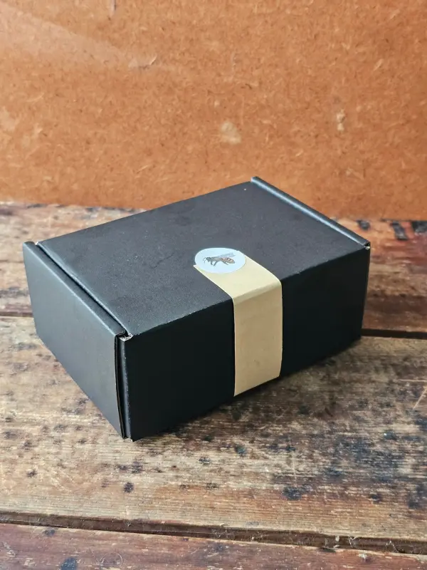 Cleopatra Mini gift set in a closed black box with a kraft belly band