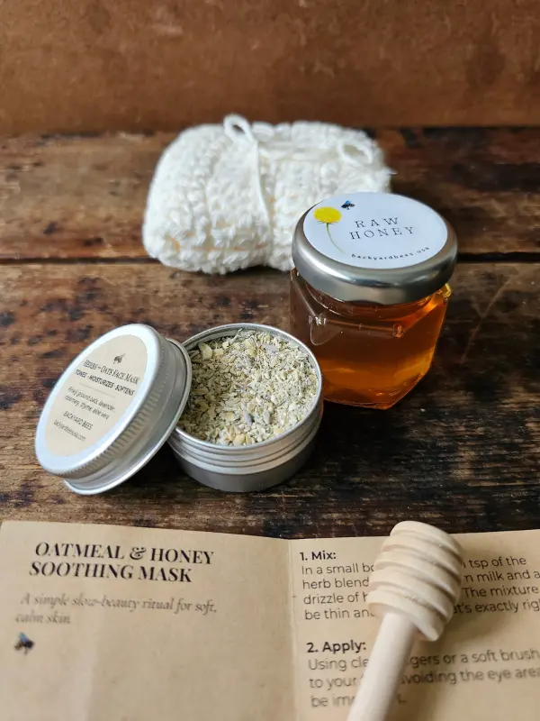 Open oatmeal and honey face mask tin beside the Cleopatra Mini washcloth, honey jar, dipper, and ritual card