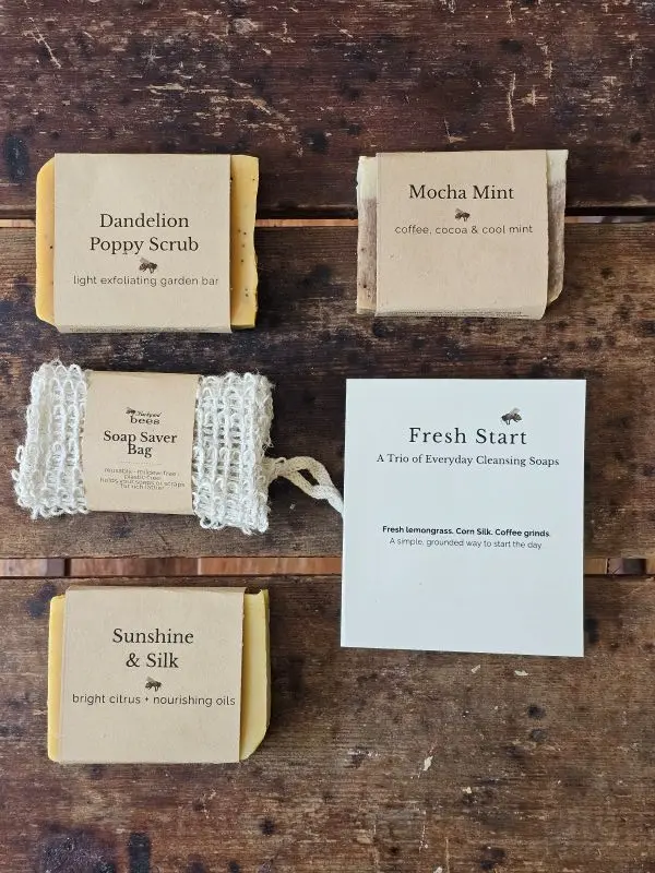 Fresh Start Flat Lay Handmade soap trio including Dandelion Poppy, Mocha Mint, Sunshine & Silk and reusable sisal soap saver bag