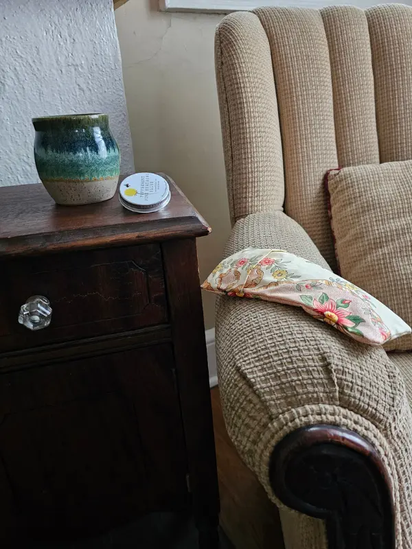 lavender eye pillow resting on chair as part of new mom self-care gift set