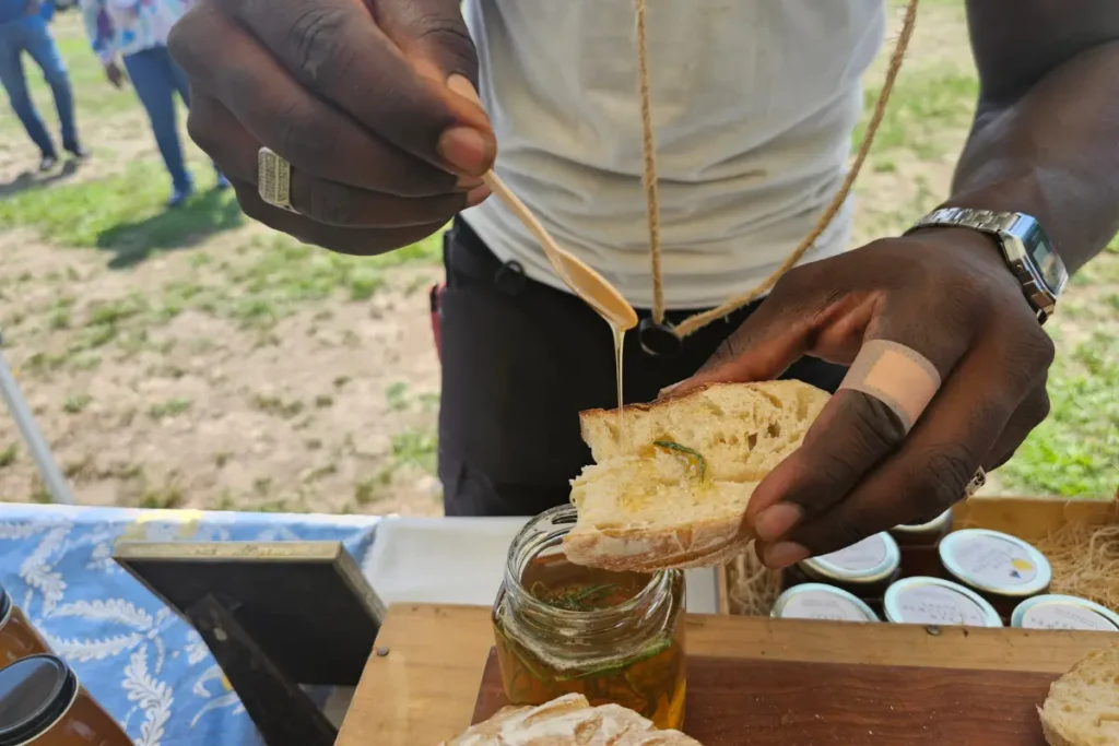 Food Safety, Fresh Corn, &Amp; Rosemary Honey 3 Farmers market customer tasting rosemary-infused honey on fresh bread
