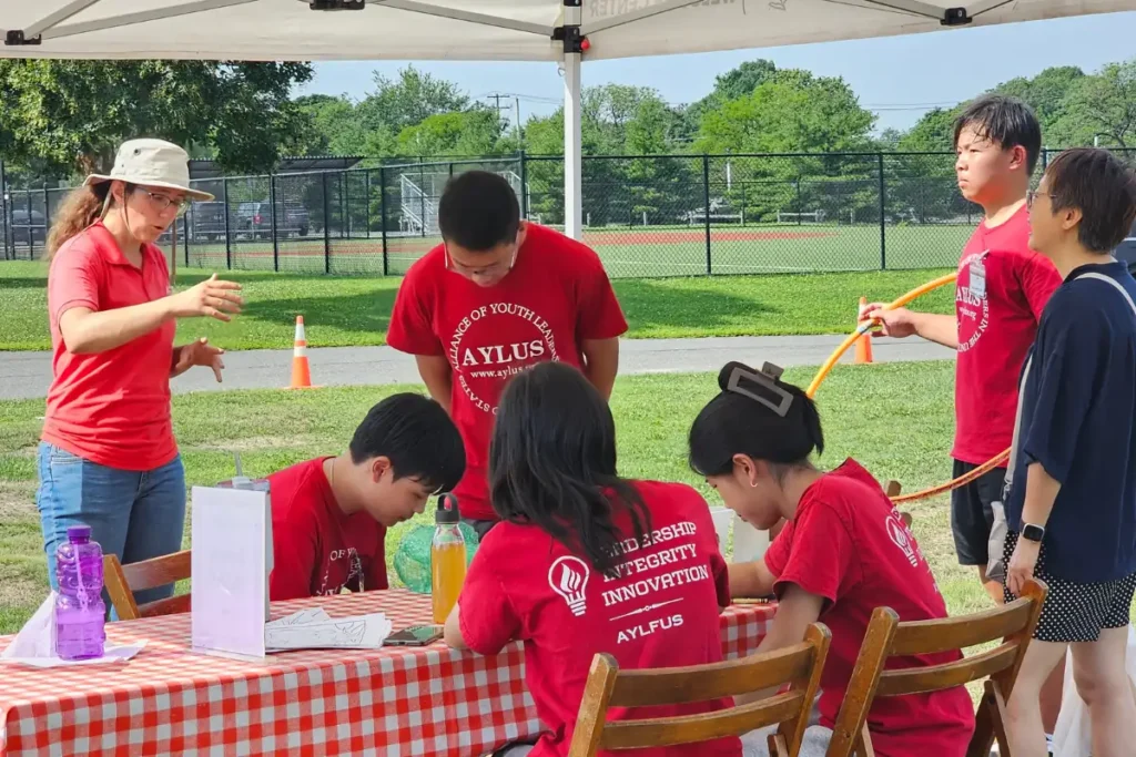 Youth volunteers organize jump ropes, hula hoops, coloring activities, and family games at the farmers market