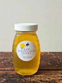 half-pound jar of Roslyn local honey on wooden table