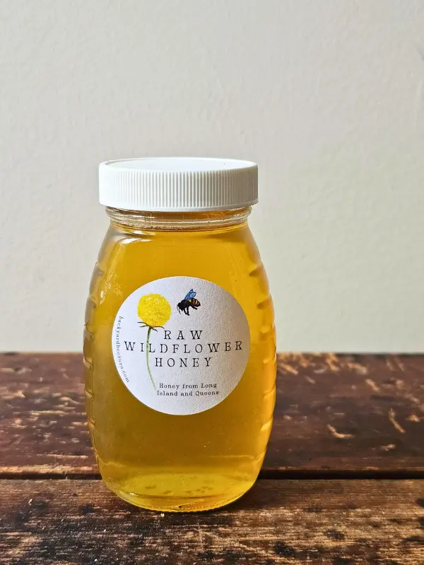 half-pound jar of Roslyn local honey on wooden table