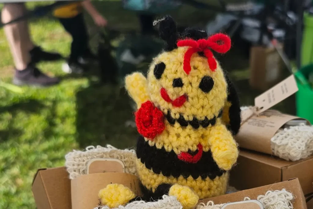 a crocheted honey bee greets people at the Backyard Bees farmers market table