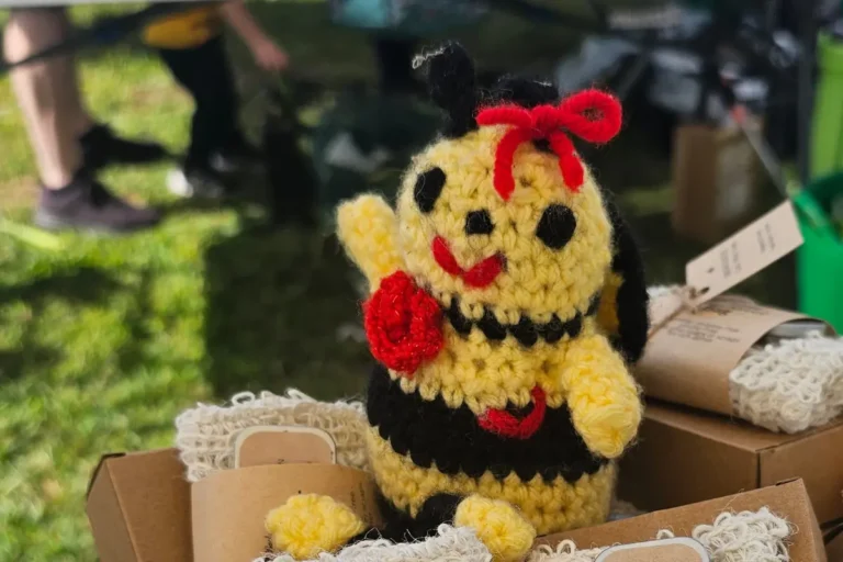 a crocheted honey bee greets people at the Backyard Bees farmers market table
