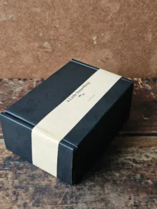 Closed black cardboard Bee Kissable gift box with kraft paper belly band