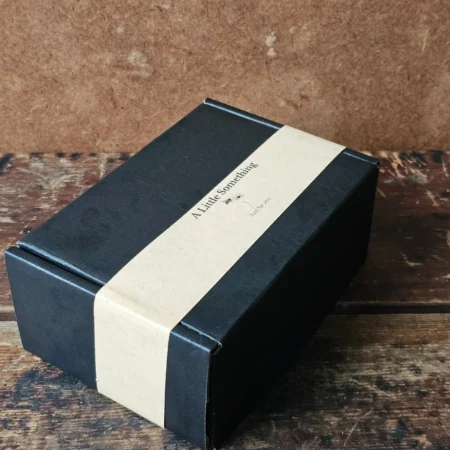 Closed black cardboard Bee Kissable gift box with kraft paper belly band