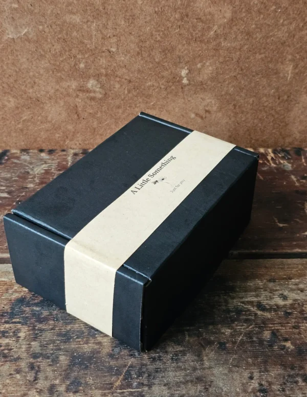 Closed black cardboard Bee Kissable gift box with kraft paper belly band