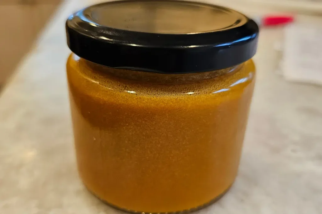 closeup of a single jar of Backyard Bees turmeric honey, 